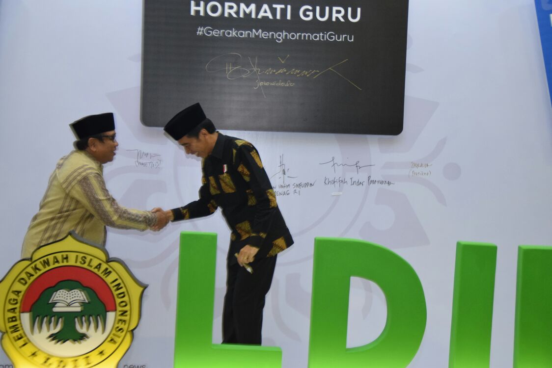 Presiden Joko Widodo berjabat tangan dengan Ketua Umum DPP LDII Abdullah Syam usai menandatangani wall of fame gerakan hormati guru di Balai Kartini Jakarta (9/11).