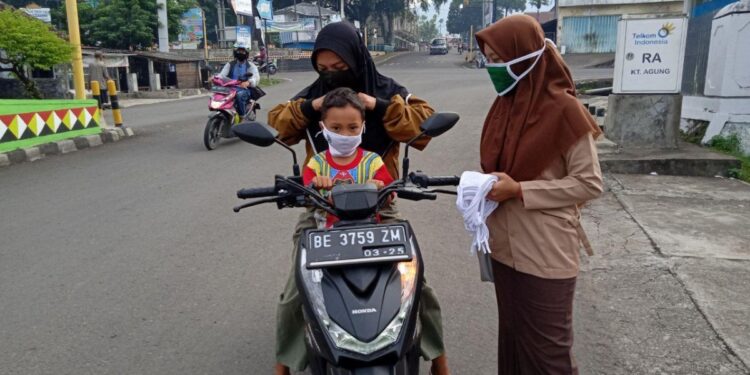 Pengurus LDII Tanggamus membagikan masker kepada warga di perempatan lampu merah Kotaagung Rabu 275 sebagai upaya pencegahan penyebaran Covid 19 Foto LINES