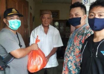 Relawan LDII Kotamobagu menyerahkan paket sembako kepada warga terdampak Covid-19 secara langsung ke rumah penerima, Minggu (7/6). Foto: LINES