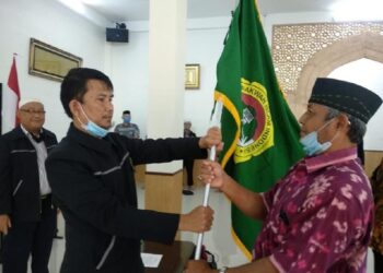 Ketua DPD LDII Sumedang Usep Aziz Solehuddin menyerahkan bendera panji LDII kepada Ketua PC LDII Cimanggung, H. Hari Dwiyono, saat prosesi pelantikan pengurus masa bakti 2020–2025 di Mazaya Boarding School, Sumedang. Foto: Dok. LINES