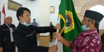 Ketua DPD LDII Sumedang Usep Aziz Solehuddin menyerahkan bendera panji LDII kepada Ketua PC LDII Cimanggung H Hari Dwiyono saat prosesi pelantikan pengurus masa bakti 20202025 di Mazaya Boarding School Sumedang Foto Dok LINES