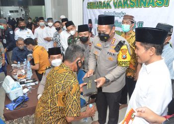 Kapolresta Sidoarjo Kombespol Kusumo Wahyu Bintoro bagikan sarung pada warga yang melakukan vaksin booster, 14 April 2022. Dok: Kontributor KIM Sidoarjo.