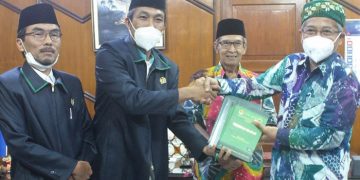 Ketua DPW LDII DIY memberikan ADART buku Munas IX LDII 2021 dan buku pedoman beribadah LDII yang diterima oleh Ketua PWM DIY Gita Danu Pranata kanan Turut mendampingi Sekretaris PWM Sukiman kedua dari kanan dan Wakil Ketua DPW LDII DIY Anji Sujiman kiri