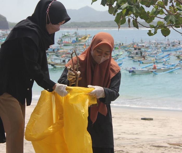 Remaja Putri LDII memunguti sampah di pantai Papuma. Dok: LINES.