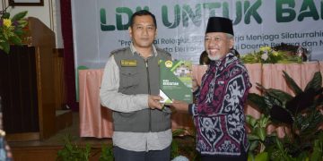 Ketua DPD LDII Gresik H Abdul Muis Zuhri menyerahkan laporan kegiatan DPD LDII Gresik 2022 pada Kepala Badan Kesatuan Bangsa dan Politik Nanang Setiawan Dok LINES