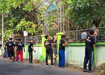 Relawan LDII mengecat pagar Tempat Pemakaman Umum (TPU) Gunung Anyar Tengah Surabaya di acara "Kerja Bersama, Bakti untuk Negeri." Jumat (4/8). Dok: LINES.