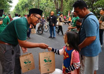 Relawan LDII Jatim membagikan bibit tanaman kepada warga Surabaya di acara Car Free Day (CFD) di Taman Bungkul Surabaya, Minggu (27/8). Dok: LINES.