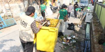 Sejumlah warga LDII gotong royong membersihkan selokan di sekitar Tempat Pemakaman Umum TPU di Jalan Gayungan I Surabaya Jumat 48 Dok LINES