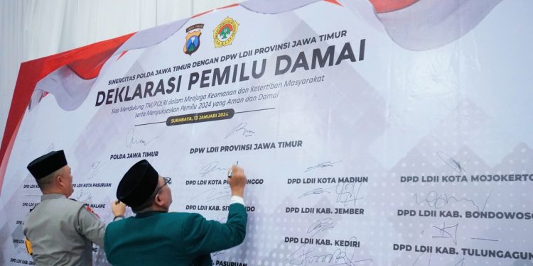 Kapolda Jatim Irjen Pol Drs. Imam Sugianto (kiri) dan Ketua DPW LDII Jatim KH Moch Amrodji Konawi menandatangani Deklarasi Pemilu Damai, Sabtu (13/1), di Aula Ponpes Sabilurrosyidin Annur, Surabaya. Dok: LINES.