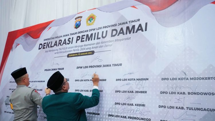 Kapolda Jatim Irjen Pol Drs. Imam Sugianto (kiri) dan Ketua DPW LDII Jatim KH Moch Amrodji Konawi menandatangani Deklarasi Pemilu Damai, Sabtu (13/1), di Aula Ponpes Sabilurrosyidin Annur, Surabaya. Dok: LINES.