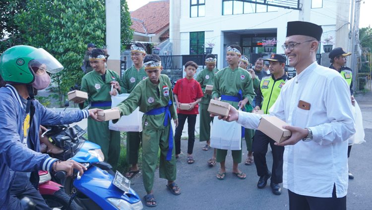 Ketua PC LDII Kecamatan Gunung Anyar Giyato kanan bagikan takjil pada pengendara di kawasan jalan raya Ir Soekarno MERR Surabaya Minggu 243 Dok LINES