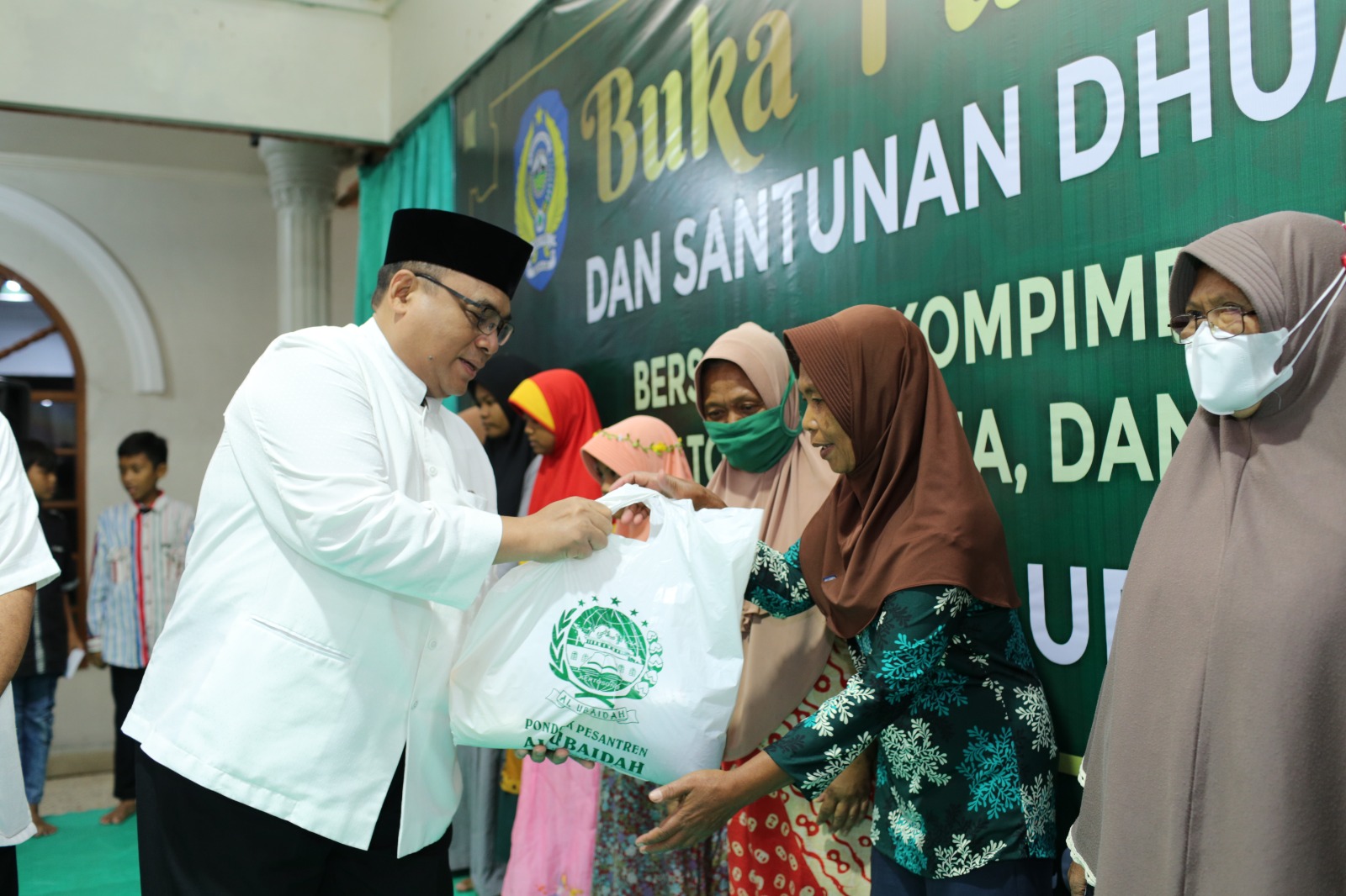 Ketua DPW LDII Jawa Timur KH Moch Amrodji Konawi menyerahkan bantuan sosial pada fakir miskin pada Safari Ramadan Ponpes Al Ubaidah, Kertosono, Jawa Timur. Dok: LINES.