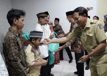 Lurah Gunung Anyar, Surabaya, Julius Gunandar bersama pengurus IPSM dan LDII, bagikan santunan kepada anak yatim, di Kantor Kecamatan Gunung Anyar, Selasa (2/4). Dok: LINES.