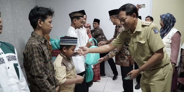 Lurah Gunung Anyar, Surabaya, Julius Gunandar bersama pengurus IPSM dan LDII, bagikan santunan kepada anak yatim, di Kantor Kecamatan Gunung Anyar, Selasa (2/4). Dok: LINES.