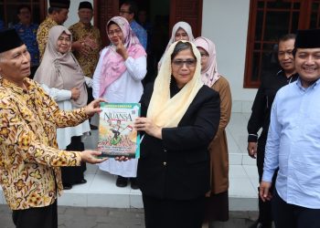 Ketua Ponpes Wali Barokah KH Sunarto (kiri) menyerahkan majalah Nuansa pada PJ Wali Kota Kediri Zanariah saat berkunjung ke Ponpes Wali Barokah, Rabu (17/4). Dok: LINES.