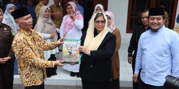 Ketua Ponpes Wali Barokah KH Sunarto kiri menyerahkan majalah Nuansa pada PJ Wali Kota Kediri Zanariah saat berkunjung ke Ponpes Wali Barokah Rabu 174 Dok LINES