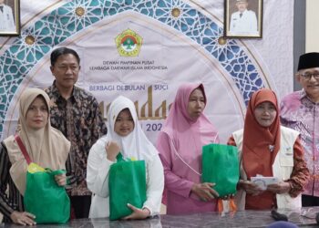 Ketua Umum DPP LDII KH Chriswanto Santoso didampingi Wakil Sekretaris DPP LDII Wahjoe Soetiono menyalurkan santunan 50 anak yatim di Kantor Kelurahan Gunung Anyar, Surabaya, pada Kamis (13/3). Dok: LINES.