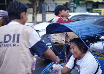 Santri Pondok Pesantren Mahasiswa (PPM) Syafiurrohman Jember membagikan takjil kepada para pengguna jalan. Aksi tersebut dilakukan di Jalan PB Sudirman seberang lampu merah SMP Negeri 2 Jember, pada Minggu (16/3). Dok: LINES.