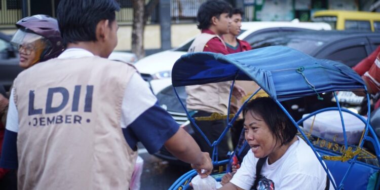 Santri Pondok Pesantren Mahasiswa (PPM) Syafiurrohman Jember membagikan takjil kepada para pengguna jalan. Aksi tersebut dilakukan di Jalan PB Sudirman seberang lampu merah SMP Negeri 2 Jember, pada Minggu (16/3). Dok: LINES.