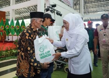Gubernur Jawa Timur, Khofifah Indar Parawansa, menyerahkan paket sembako kepada warga prasejahtera dalam acara pembukaan Perkemahan Akhir Tahun Ajaran Cinta Alam Indonesia (Permata CAI) ke-46, yang digelar pada Senin (30/6) di Bumi Perkemahan Kosambiwojo, Wonosalam. Dok: LINES.