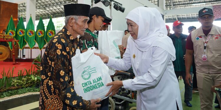 Gubernur Jawa Timur, Khofifah Indar Parawansa, menyerahkan paket sembako kepada warga prasejahtera dalam acara pembukaan Perkemahan Akhir Tahun Ajaran Cinta Alam Indonesia (Permata CAI) ke-46, yang digelar pada Senin (30/6) di Bumi Perkemahan Kosambiwojo, Wonosalam. Dok: LINES.