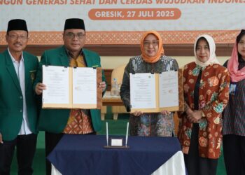 Ketua DPW LDII Jawa Timur, KH Amrodji (dua dari kiri), bersama Kepala Perwakilan BKKBN Provinsi Jawa Timur, Maria Ernawati (tiga dari kanan), menunjukkan dokumen Perjanjian Kerja Sama (PKS) usai penandatanganan di Gedung DPD LDII Kabupaten Gresik, Minggu (27/7/2025). Kerja sama ini bertujuan mendukung program percepatan penurunan stunting dan penguatan ketahanan keluarga, sebagai bagian dari kontribusi menuju Indonesia Emas 2045. Hadir menyaksikan jajaran pengurus LDII dan BKKBN Jawa Timur. Dok: LINES.