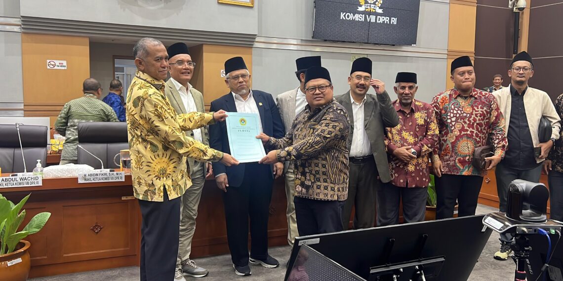 Sekretaris Umum DPP LDII Dody Taufiq Wijaya menyerahkan dokumen berisi 10 poin usulan perbaikan RUU Penyelenggaraan Ibadah Haji dan Umrah kepada Ketua Panja Haji Komisi VIII DPR RI Singgih Januratmoko kiri dalam Rapat Dengar Pendapat Umum RDPU di Gedung Nusantara II Jakarta Rabu 2082025 Dok LINES