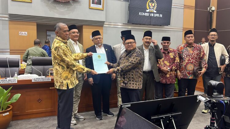 Sekretaris Umum DPP LDII Dody Taufiq Wijaya menyerahkan dokumen berisi 10 poin usulan perbaikan RUU Penyelenggaraan Ibadah Haji dan Umrah kepada Ketua Panja Haji Komisi VIII DPR RI Singgih Januratmoko kiri dalam Rapat Dengar Pendapat Umum RDPU di Gedung Nusantara II Jakarta Rabu 2082025 Dok LINES