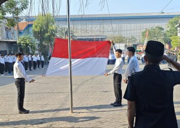 Peserta upacara memberikan penghormatan saat bendera Merah Putih dikibarkan oleh santri Al-Huda Tundungan pada peringatan HUT ke-80 RI, di halaman Masjid Al-Huda, Krian, Sidoarjo. Dok: LINES.