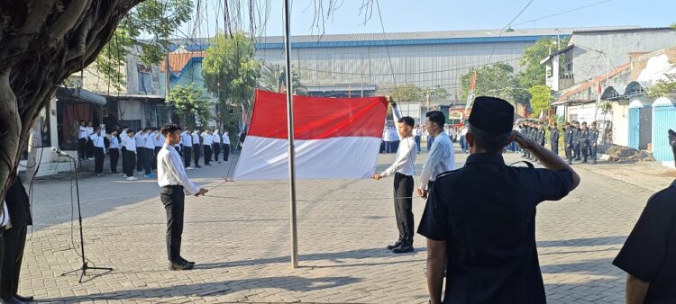 Peserta upacara memberikan penghormatan saat bendera Merah Putih dikibarkan oleh santri Al-Huda Tundungan pada peringatan HUT ke-80 RI, di halaman Masjid Al-Huda, Krian, Sidoarjo. Dok: LINES.