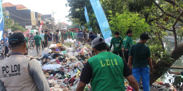Ratusan relawan LDII membersihkan tumpukan sampah di bantaran Sungai Kali Tebu, Kenjeran, Surabaya, Minggu (10/8), dalam kerja bakti massal menyambut HUT ke-80 RI. Dok: LINES.