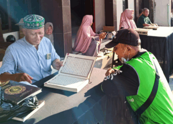 Seorang pengemudi ojek online menyetorkan hafalan Al-Qur’an di hadapan panitia pada kegiatan sosial “Berbagi Kebaikan” yang digelar PC LDII Kaliwates bersama Takmir Masjid Ar-Royan, Jember, Minggu (21/9). Warga yang berhasil menyetorkan hafalannya berhak membawa pulang mushaf Al-Qur’an baru. Dok. LINES.