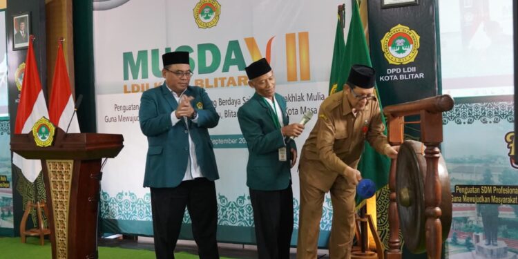 Asisten 1 Bidang Pemerintahan, Perekonomian, dan Kesejahteraan Rakyat (Kesra) Pemkot Blitar, Mokhamad Sidik (kanan), didampingi Ketua DPW LDII Jawa Timur KH Moch Amrodji Konawi (tengah) memukul gong sebagai tanda dibukanya Musyawarah Daerah (Musda) VII DPD LDII Kota Blitar, Selasa (23/9/2025). Forum lima tahunan ini menjadi momentum penting bagi LDII dalam merumuskan program kerja dan melakukan regenerasi kepemimpinan. Dok. LINES.