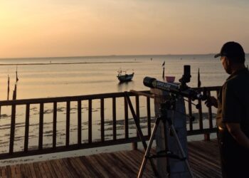 Seorang anggota Tim Falakiyah LDII mengamati hilal dengan teleskop di Pantai Gebang, Bangkalan, Senin (22/9). Pengamatan ini menjadi bagian dari rukyatul hilal awal bulan Rabiul Akhir 1447 H di titik resmi Kanwil Kemenag Jatim. Dok. LINES.