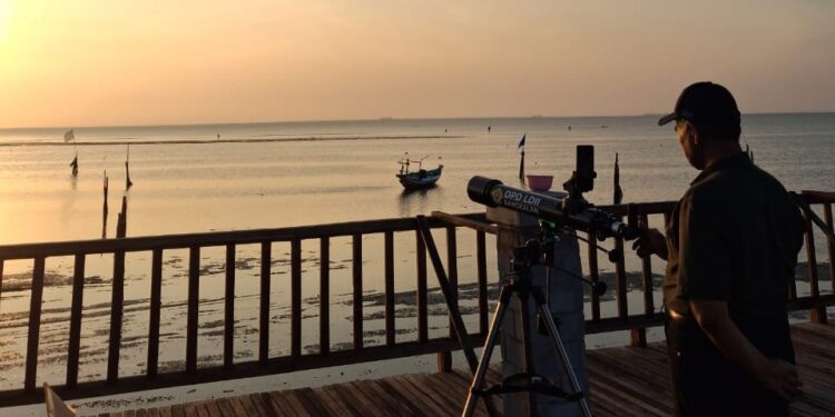 Seorang anggota Tim Falakiyah LDII mengamati hilal dengan teleskop di Pantai Gebang, Bangkalan, Senin (22/9). Pengamatan ini menjadi bagian dari rukyatul hilal awal bulan Rabiul Akhir 1447 H di titik resmi Kanwil Kemenag Jatim. Dok. LINES.