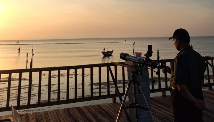Seorang anggota Tim Falakiyah LDII mengamati hilal dengan teleskop di Pantai Gebang Bangkalan Senin 229 Pengamatan ini menjadi bagian dari rukyatul hilal awal bulan Rabiul Akhir 1447 H di titik resmi Kanwil Kemenag Jatim Dok LINES