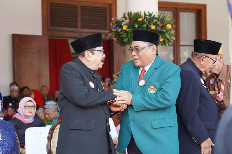 Ketua DPW LDII Jawa Timur Moch Amrodji Konawi kanan berbincang dengan Soekarwo Gubernur Jawa Timur periode 20082013 dan 20132018 usai upacara peringatan Hari Ulang Tahun ke 80 Provinsi Jawa Timur di Gedung Negara Grahadi Surabaya Minggu 12102025 Keduanya tampak berdiskusi hangat mengenai peran kolaborasi masyarakat dan pemerintah dalam memperkuat ketahanan pangan serta pembangunan daerah Dok LINES