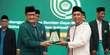 Ketua DPD LDII Sidoarjo Fauzan menyerahkan cinderamata kepada Asisten II Pemerintah Kabupaten Sidoarjo Mahmud dalam rangkaian kegiatan Musda X LDII Sidoarjo yang digelar pada Minggu 2610 Dok LINES Sidoarjo