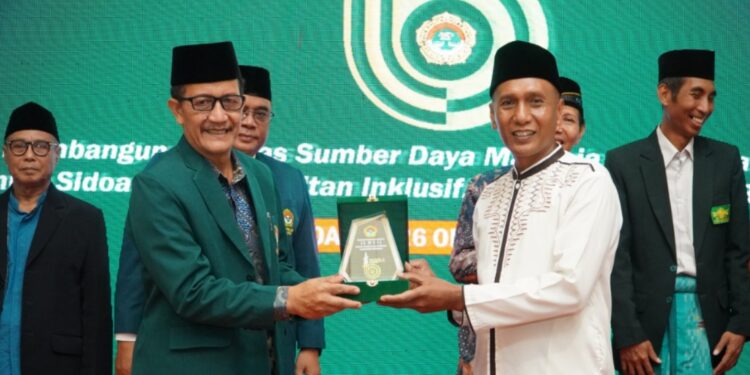Ketua DPD LDII Sidoarjo, Fauzan menyerahkan cinderamata kepada Asisten II Pemerintah Kabupaten Sidoarjo, Mahmud dalam rangkaian kegiatan Musda X LDII Sidoarjo yang digelar pada Minggu (26/10). (Dok. LINES Sidoarjo)