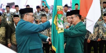 Ketua terpilih DPD LDII Kabupaten Sidoarjo masa bakti 20252030 M Fauzan kanan menerima bendera pataka organisasi dalam prosesi pelantikan usai Musyawarah Daerah Musda X LDII Sidoarjo di Gedung Pondok Pesantren Al Barokah Sruni Minggu 2610 Dok LINES Sidoarjo