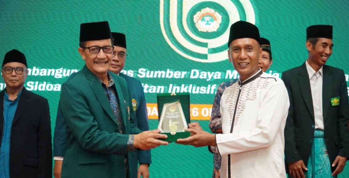 Ketua DPD LDII Sidoarjo, Fauzan menyerahkan cinderamata kepada Asisten II Pemerintah Kabupaten Sidoarjo, Mahmud dalam rangkaian kegiatan Musda X yang digelar pada Minggu (26/10). Dok: LINES.