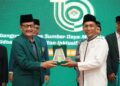 Ketua DPD LDII Sidoarjo, Fauzan menyerahkan cinderamata kepada Asisten II Pemerintah Kabupaten Sidoarjo, Mahmud dalam rangkaian kegiatan Musda X yang digelar pada Minggu (26/10). Dok: LINES.