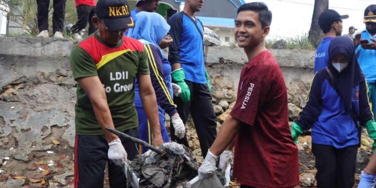 Pemuda LDII Pamekasan bersama relawan lingkungan mengangkat tumpukan sampah di kawasan Pantai Branta, Pamekasan, saat aksi bersih pantai memperingati World Clean Up Day 2025, Minggu (12/10/2025). Kegiatan ini menjadi ajang kolaborasi masyarakat dalam menjaga kebersihan dan kelestarian lingkungan. Dok. LINES.