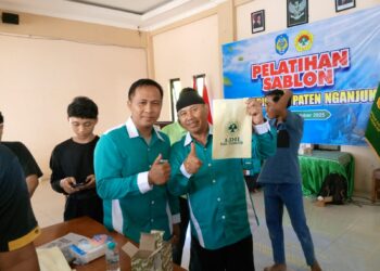 Ketua DPD LDII Kabupaten Nganjuk, Murkani (kanan), menunjukkan hasil karya peserta Pelatihan Sablon yang digelar di Aula DPD LDII Nganjuk, Minggu (19/10/2025). Kegiatan ini membekali generasi muda LDII dengan keterampilan wirausaha guna mendorong kemandirian ekonomi. (Dok. LINES Nganjuk)