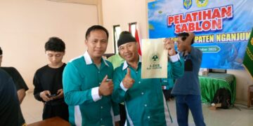 Ketua DPD LDII Kabupaten Nganjuk Murkani kanan menunjukkan hasil karya peserta Pelatihan Sablon yang digelar di Aula DPD LDII Nganjuk Minggu 19102025 Kegiatan ini membekali generasi muda LDII dengan keterampilan wirausaha guna mendorong kemandirian ekonomi Dok LINES Nganjuk
