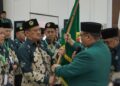 Akhmad Setiadi menerima bendera pataka sebagai tanda amanah usai terpilih kembali menjadi Ketua DPD LDII Kota Surabaya masa bakti 2025–2030, dalam Musda X LDII Kota Surabaya di Gedung Serba Guna Sabilurrosyidin, Minggu (9/11). (Foto: Dok. LINES Surabaya)