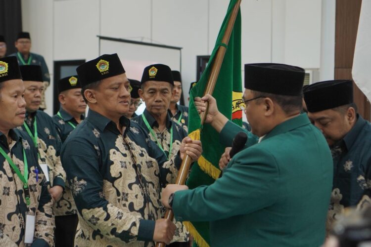 Akhmad Setiadi menerima bendera pataka sebagai tanda amanah usai terpilih kembali menjadi Ketua DPD LDII Kota Surabaya masa bakti 2025–2030, dalam Musda X LDII Kota Surabaya di Gedung Serba Guna Sabilurrosyidin, Minggu (9/11). (Foto: Dok. LINES Surabaya)