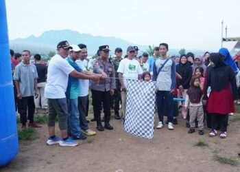 Wakil Ketua Komisi D DPRD Jawa Timur, didampingi jajaran Forkopimka Tarokan, mengibarkan bendera start sebagai tanda dimulainya Jalan Sehat OSAKA 2025 di Lapangan Pojok, Desa Bulusari, Kecamatan Tarokan, Kediri, Minggu (30/11). Kegiatan yang diselenggarakan LDII Kediri itu diikuti ribuan peserta dari berbagai kecamatan, termasuk masyarakat umum serta para santri dari pondok pesantren. Foto: Dok. LINES Kediri.