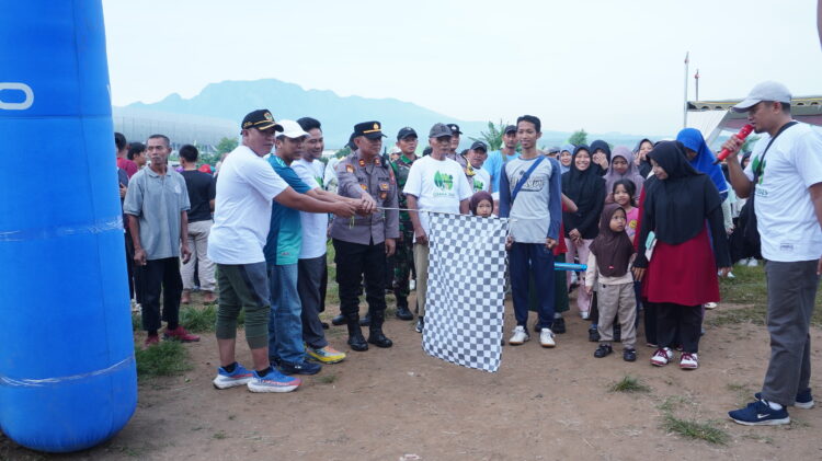 Wakil Ketua Komisi D DPRD Jawa Timur didampingi jajaran Forkopimka Tarokan mengibarkan bendera start sebagai tanda dimulainya Jalan Sehat OSAKA 2025 di Lapangan Pojok Desa Bulusari Kecamatan Tarokan Kediri Minggu 3011 Kegiatan yang diselenggarakan LDII Kediri itu diikuti ribuan peserta dari berbagai kecamatan termasuk masyarakat umum serta para santri dari pondok pesantren Foto Dok LINES Kediri