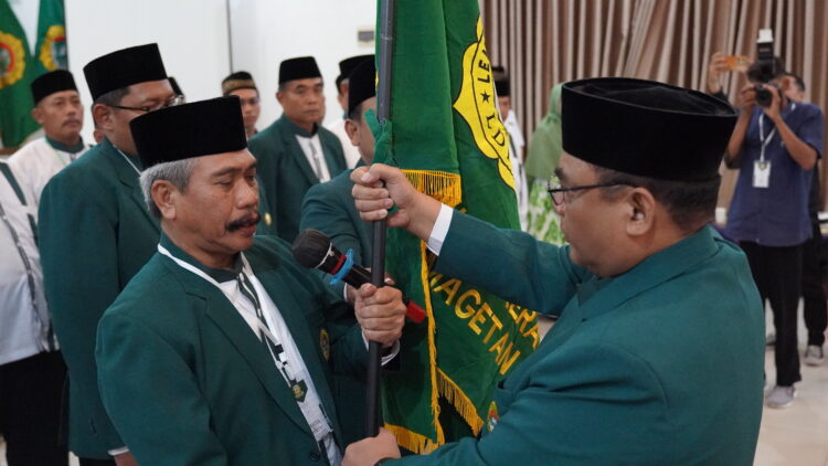 Ketua DPD LDII Kabupaten Magetan terpilih, Joko Pramono (kiri), menerima panji organisasi dalam prosesi pelantikan pada Musyawarah Daerah (Musda) X LDII Magetan di RM Putra Nirwana, Plaosan, Magetan. Prosesi ini disaksikan jajaran pengurus dan ketua PC LDII se-Kabupaten Magetan sebagai simbol amanah kepemimpinan untuk periode 2025–2030. (Foto: Dok. LINES Jatim)